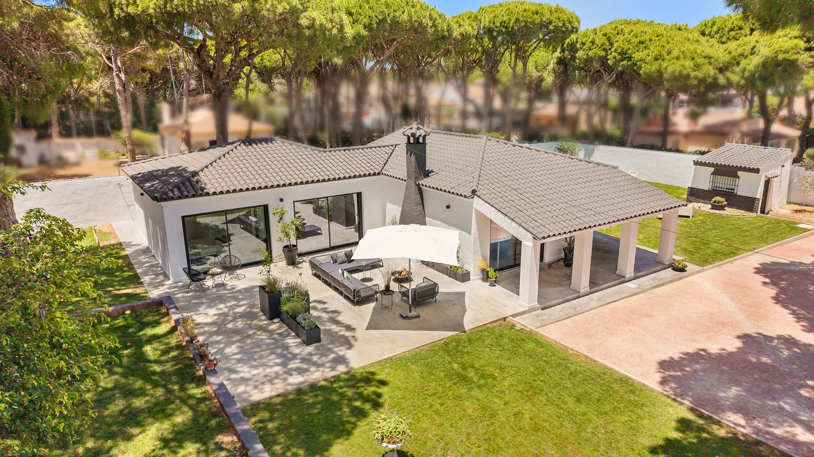Villa Juju desde el aire: casa con terraza y jardín bajo los pinos