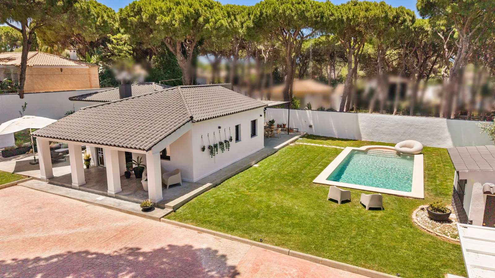 Villa Juju from the air: house, garden and pool beneath pine trees